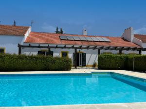 a swimming pool in front of a house at Agroturismo Horta Da Vila in Alvito
