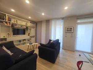 ein Wohnzimmer mit zwei Sofas und einem Fernseher in der Unterkunft La Palma in Lerici