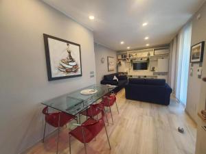 ein Wohnzimmer mit einem Glastisch und roten Stühlen in der Unterkunft La Palma in Lerici