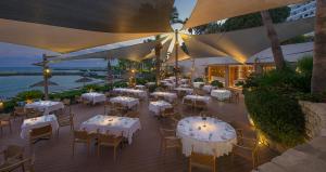 a restaurant with tables and chairs on a deck at Amathus Beach Hotel Limassol in Limassol