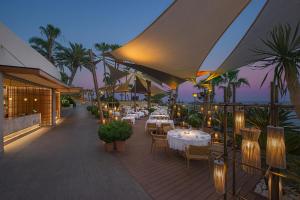 a restaurant with tables and chairs on a deck at Amathus Beach Hotel Limassol in Limassol