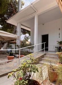 Casa blanca con porche y escaleras en Panos Apartments, en Artemida
