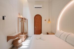 a bedroom with a white bed and a wooden door at Mint Villa with Jacuzzi Pool in George Town +17 photos