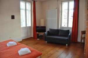 1 dormitorio con 1 cama, 1 silla y TV en Gästehaus stuttgART36, en Maulbronn