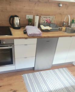 eine Küche mit weißen Schränken und einer Theke mit einer Spüle in der Unterkunft ZEMAN Old Town Apartment in Sarajevo + 2 Fotos