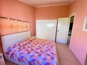 a bedroom with a bed with a colorful comforter at Casa con giardino con climatizzatore!!! in Costa Rei