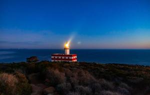 Isola del GiglioFaro Capel Rosso的一座灯塔,位于靠近大海的山顶上