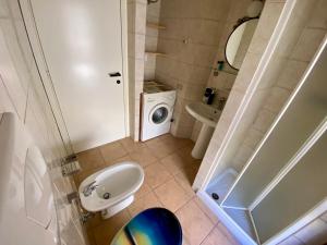 a small bathroom with a sink and a washing machine at Casa con giardino con climatizzatore!!! in Costa Rei +20 photos