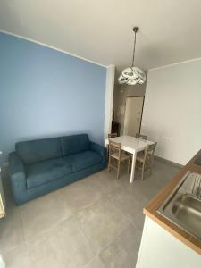 a living room with a blue couch and a table at A casa di Vitto in Borghetto Santo Spirito +6 photos