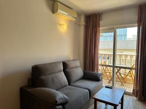 ein Wohnzimmer mit Couch und großem Fenster in der Unterkunft Homely Apartments Sol Y Mar in Torrevieja