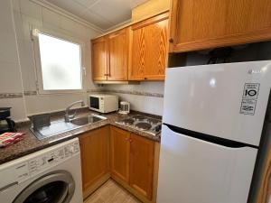 eine Küche mit einem weißen Kühlschrank und einem Geschirrspüler in der Unterkunft Homely Apartments Sol Y Mar in Torrevieja