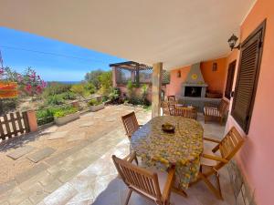 a patio with a table and chairs and a fireplace at Casa con giardino con climatizzatore!!! in Costa Rei
