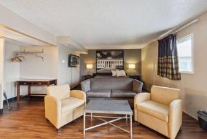 un soggiorno con un divano e un letto di Super 8 by Wyndham Millbury/Toledo a Millbury