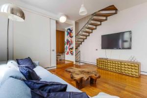 a living room with a couch and a tv at LUVI - Pietro Custodi in Milan