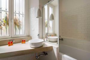 a bathroom with two sinks and a tub and windows at LUVI - Pietro Custodi in Milan