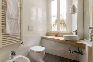 a bathroom with a toilet and a sink and a window at LUVI - Pietro Custodi in Milan