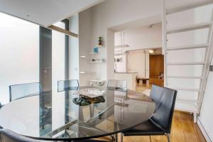 a glass dining table and chairs in a room at LUVI - Pietro Custodi in Milan