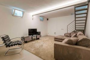 a living room with a couch and a tv at LUVI - Pietro Custodi in Milan