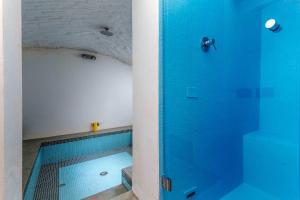 a swimming pool in a bathroom with a blue shower at LUVI - Pietro Custodi in Milan