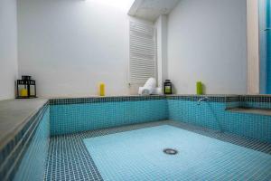 a swimming pool with a blue tiled floor and a window at LUVI - Pietro Custodi in Milan