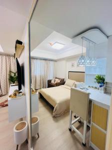 a bedroom with a bed and a desk with a desk at Azure North- Serenity Homes by J&J Condo rentals in Lagundi