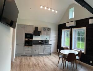 a kitchen with a table and chairs in a room at Husslåttene apartments in Skei