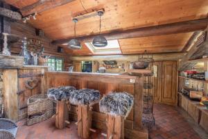 een keuken met houten wanden en een aanrecht met krukken bij Chalet authentique luxe piscine in Les Contamines-Montjoie