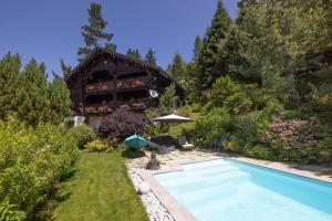 een huis met een zwembad in een tuin bij Chalet authentique luxe piscine in Les Contamines-Montjoie