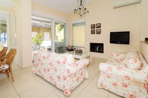 A television and/or entertainment centre at Helios Villa Sea Front - 3 bedrooms 7 guests