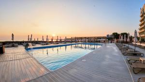 Ein Swimmingpool mit Sonnenuntergang im Hintergrund in der Unterkunft Hotel Malibu in Mamaia