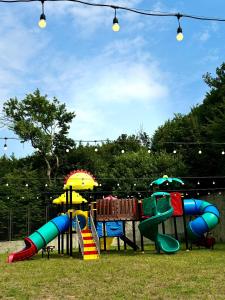 a playground with colorful slides and umbrellas at Teghenis Resort in Tsaghkadzor