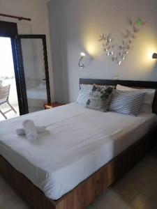a large bed with white sheets and pillows in a bedroom at Avra Ηouse in Kriopigi