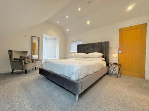a bedroom with a large bed and a chair at Eagles Cottage, 3 - Bed, Sleeps 6, Pets Welcome - Ulverston in Ulverston +43 photos