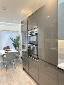 a kitchen with a stainless steel refrigerator and a table at Eagles Cottage, 3 - Bed, Sleeps 6, Pets Welcome - Ulverston in Ulverston