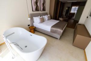 a bathroom with a bed and a bath tub and a sink at Regent Resort Budva in Budva