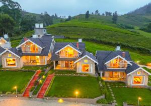 a large house with a hill in the background at AJ Gable Clouds Ooty by VOYE HOMES - Serene Stay Near Avalanche Emerald Lake in Ooty
