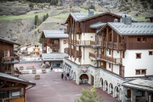 a group of buildings with people walking in a courtyard at Résidence Les Balcons de Val Cenis Village in Lanslevillard
