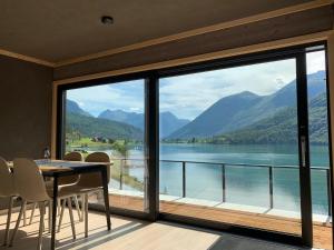 a dining room with a view of a lake and mountains at Stryn Golden Resort - Panorama II in Stryn
