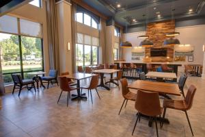 un restaurant avec des tables, des chaises et des fenêtres dans l'établissement Hampton Inn & Suites Spartanburg-I-26-Westgate Mall, à Spartanburg