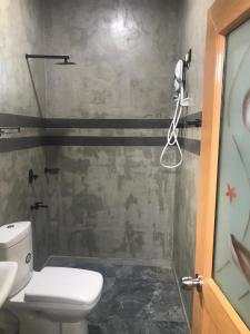 a small bathroom with a toilet and a shower at Flip Flop Inn Mirissa in Mirissa