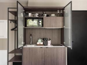a kitchen with wooden cabinets and a sink at Numa Munich Obersendling in Munich +44 photos