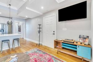 un soggiorno con TV a schermo piatto a parete di Chic Condo Near French Quarter Stay a New Orleans