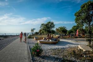 a group of people sitting on a bench near the beach at Casa Benessere Istria in Vodnjan
