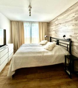 a bedroom with a large bed and a television at Apartament Arte Povera in Słubice