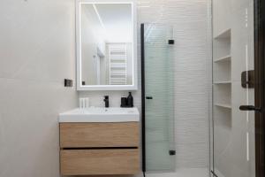 ein Badezimmer mit Waschbecken und Glasdusche in der Unterkunft Nowoczesny Apartament Przy Plaży z Parkingiem by Noclegi Renters in Ustronie Morskie