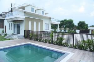 a house with a swimming pool in front of a house at Raj Farms Luxury Villa and Private Pool Near Kukus in Jaipur