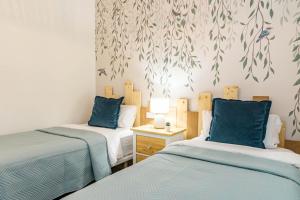 a room with two beds with blue pillows and a wall at INF31J - Stunning holiday home next to beach in Estepona +41 photos