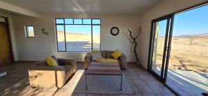 a living room with two couches and a coffee table at Wüstenquell Lodge in Arandis