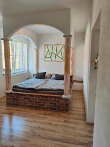 a bedroom with a bed on a brick bed frame at Ferienwohnung Dorfleben - 4 Schlafzimmer für Familien & Teams in Windisch Minihof
