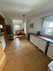 a kitchen with white cabinets and a wooden floor at AU-4 Ferienwohnung in Lofer